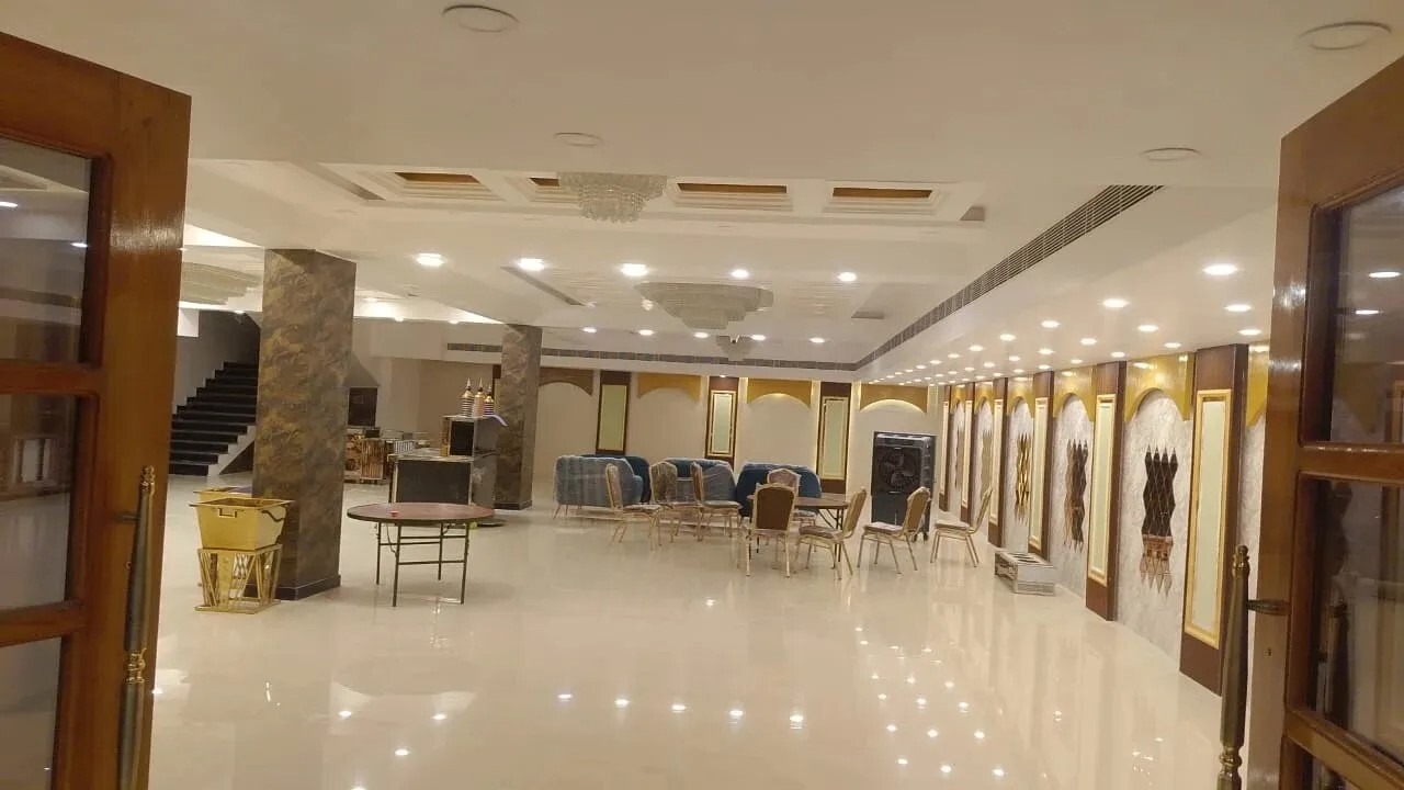 Elegant banquet hall interior with modern lighting, marble flooring, and seating arrangement.